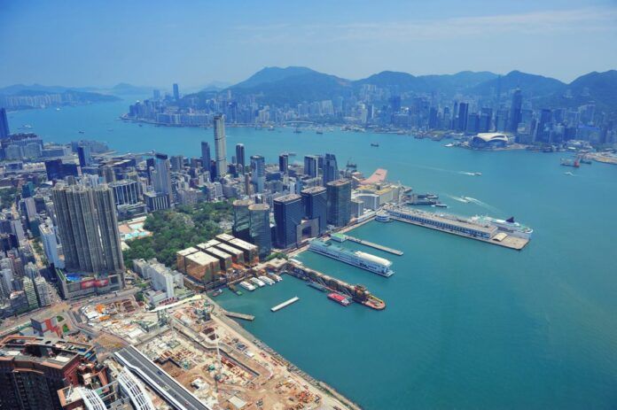 hong kong aerial view panorama with urban skyscrapers boat and sea